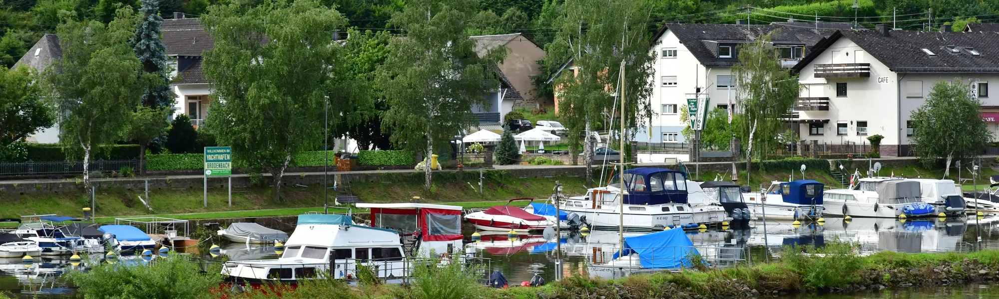 Motorboote und Segelboote in einer Marina an der Mosel